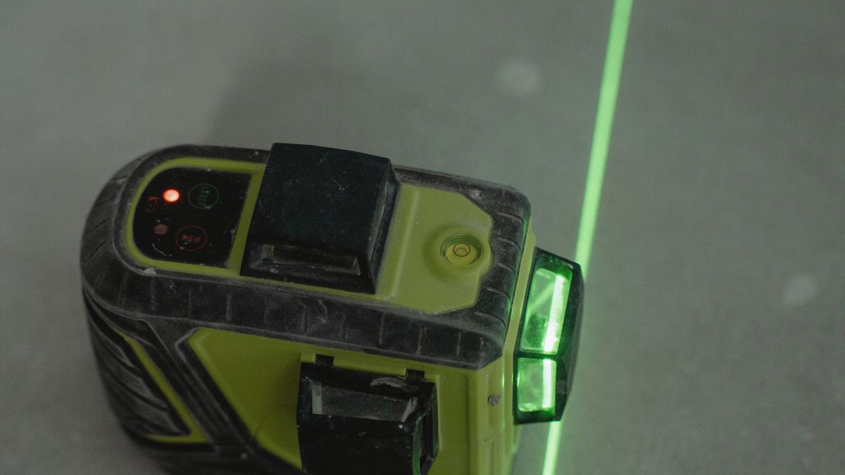 A laser level projecting a line across a floor during an elevation survey