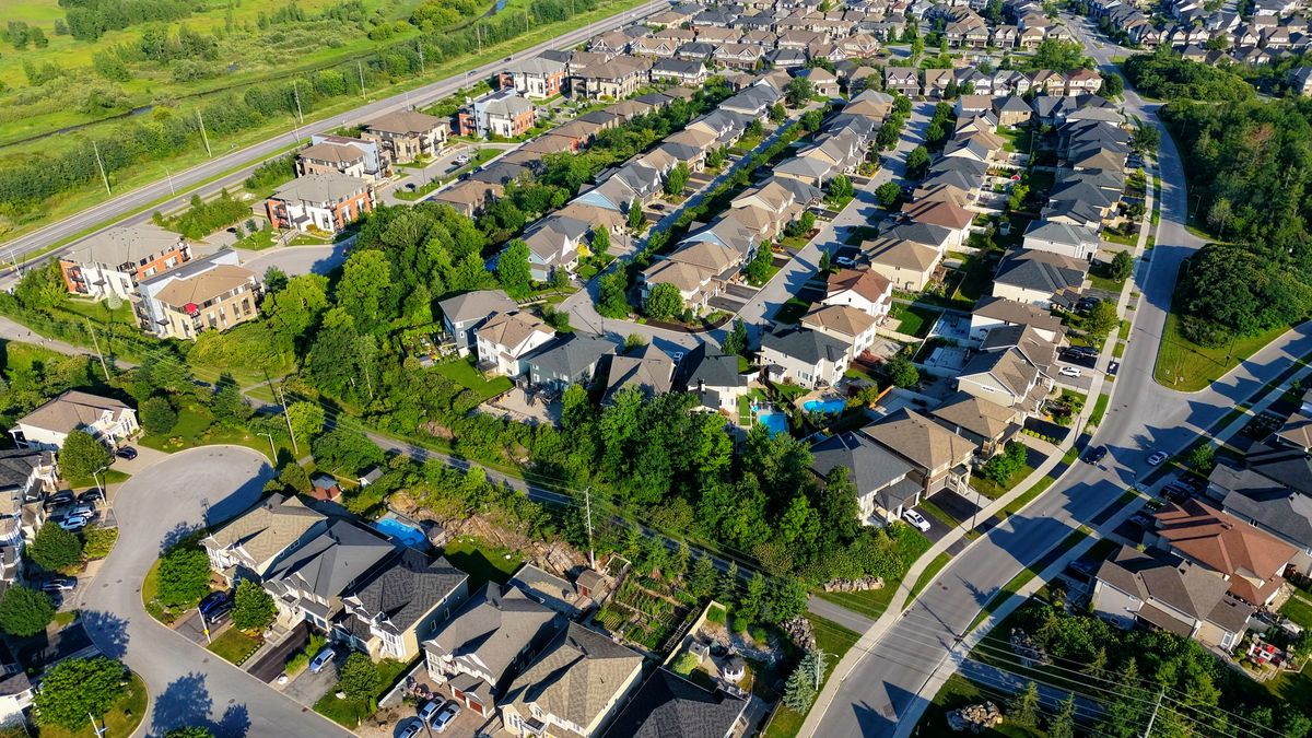 Aerial view of a recently built subdivision of similar houses on curving streets